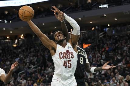 Jan 26, 2024; Milwaukee, Wisconsin, USA;  Cleveland Cavaliers guard Donovan Mitchell (45) reaches for a rebound in front of Milwaukee Bucks forward Bobby Portis (9) during the second quarter at Fiserv Forum. Mandatory Credit: Jeff Hanisch-USA TODAY Sports