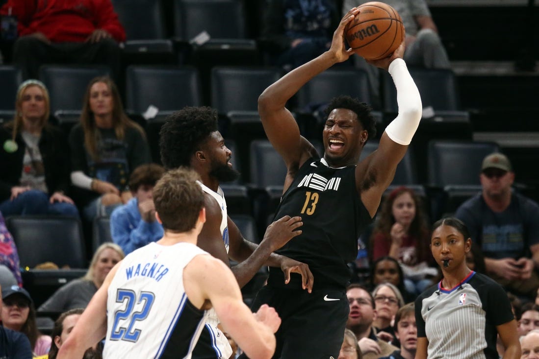 Jan 26, 2024; Memphis, Tennessee, USA; Memphis Grizzlies forward-center Jaren Jackson Jr. (13) collects a rebound over Orlando Magic forward Jonathan Isaac (1) during the first half at FedExForum. Mandatory Credit: Petre Thomas-USA TODAY Sports