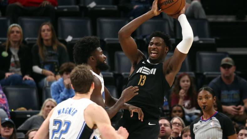 Jan 26, 2024; Memphis, Tennessee, USA; Memphis Grizzlies forward-center Jaren Jackson Jr. (13) collects a rebound over Orlando Magic forward Jonathan Isaac (1) during the first half at FedExForum. Mandatory Credit: Petre Thomas-USA TODAY Sports