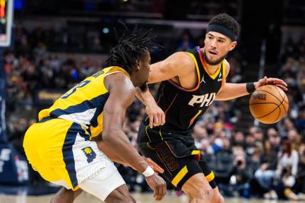 Jan 26, 2024; Indianapolis, Indiana, USA; Phoenix Suns guard Devin Booker (1) dribbles the ball while Indiana Pacers forward Aaron Nesmith (23) defends in the second half at Gainbridge Fieldhouse. Mandatory Credit: Trevor Ruszkowski-USA TODAY Sports
