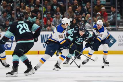 Jan 26, 2024; Seattle, Washington, USA; St. Louis Blues center Jordan Kyrou (25) and Seattle Kraken center Yanni Gourde (37) and St. Louis Blues left wing Pavel Buchnevich (89) chase the puck during the third period at Climate Pledge Arena. Mandatory Credit: Steven Bisig-USA TODAY Sports