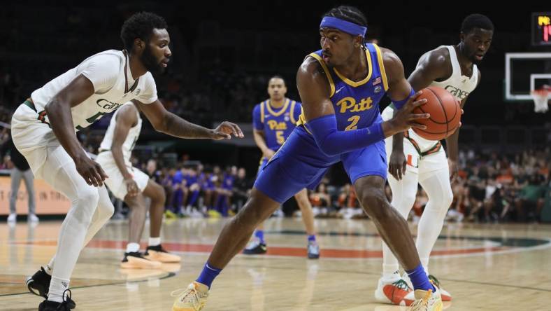 Jan 27, 2024; Coral Gables, Florida, USA; Pittsburgh Panthers forward Blake Hinson (2) protects the basketball from Miami Hurricanes guard Wooga Poplar (5) during the first half at Watsco Center. Mandatory Credit: Sam Navarro-USA TODAY Sports