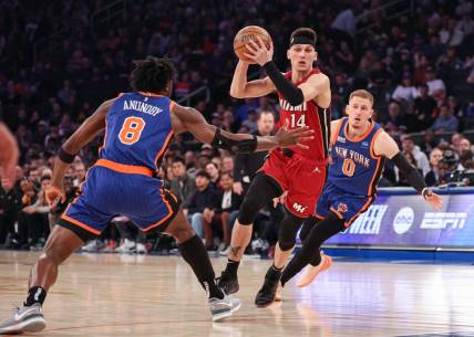 Jan 27, 2024; New York, New York, USA; Miami Heat guard Tyler Herro (14) drives to the basket after the game New York Knicks forward OG Anunoby (8) and guard Donte DiVincenzo (0) during the first half at Madison Square Garden. Mandatory Credit: Vincent Carchietta-USA TODAY Sports