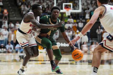 Jan 27, 2024; Laramie, Wyoming, USA; Colorado State Rams forward Isaiah Stevens (4) controls the ball against Wyoming Cowboys guard Akuel Kot (13) during the first half at Arena-Auditorium. Mandatory Credit: Troy Babbitt-USA TODAY Sports