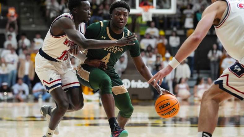 Jan 27, 2024; Laramie, Wyoming, USA; Colorado State Rams forward Isaiah Stevens (4) controls the ball against Wyoming Cowboys guard Akuel Kot (13) during the first half at Arena-Auditorium. Mandatory Credit: Troy Babbitt-USA TODAY Sports