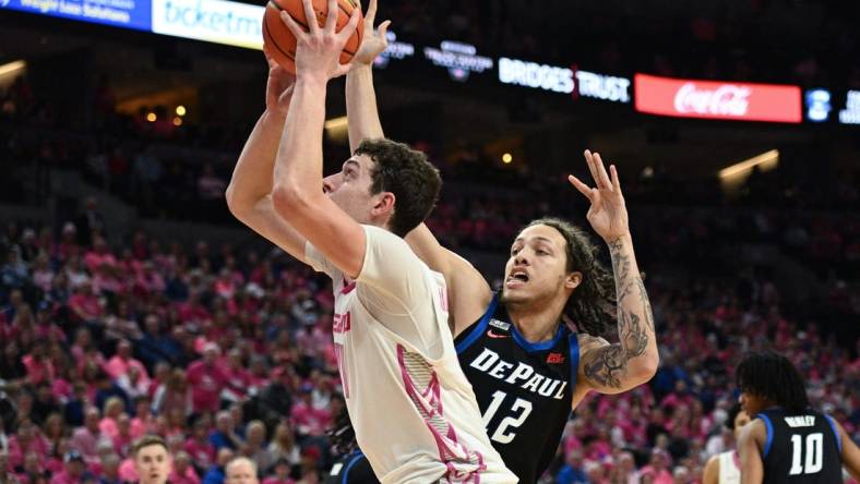 Jan 27, 2024; Omaha, Nebraska, USA; Creighton Bluejays center Ryan Kalkbrenner (11) scores against DePaul Blue Demons forward Mac Etienne (12) in the second half at CHI Health Center Omaha. Mandatory Credit: Steven Branscombe-USA TODAY Sports