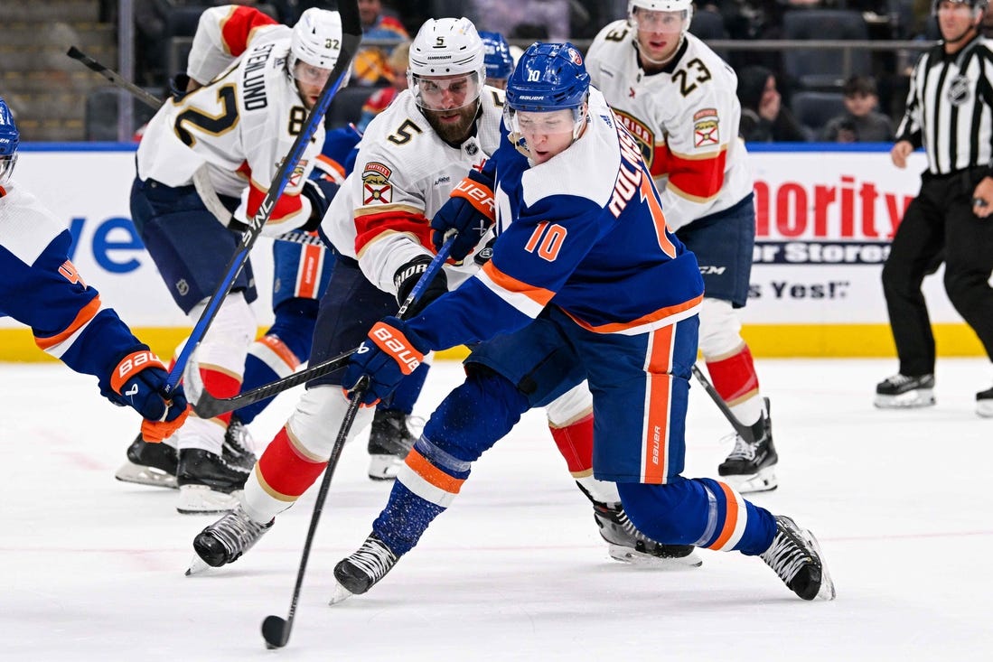 Jan 27, 2024; Elmont, New York, USA; New York Islanders right wing Simon Holmstrom (10) shoots and scores a goal against the Florida Panthers during the second period at UBS Arena. Mandatory Credit: Dennis Schneidler-USA TODAY Sports