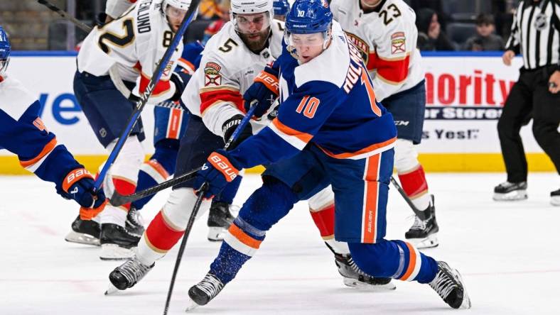 Jan 27, 2024; Elmont, New York, USA; New York Islanders right wing Simon Holmstrom (10) shoots and scores a goal against the Florida Panthers during the second period at UBS Arena. Mandatory Credit: Dennis Schneidler-USA TODAY Sports