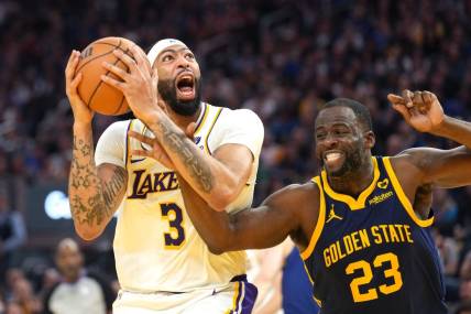 Jan 27, 2024; San Francisco, California, USA; Los Angeles Lakers forward Anthony Davis (3) shoots while being fouled by Golden State Warriors forward Draymond Green (23) during the second quarter at Chase Center. Mandatory Credit: Darren Yamashita-USA TODAY Sports