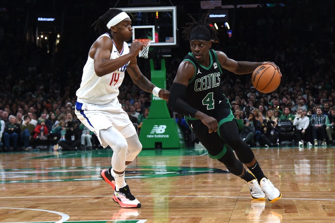 Jan 27, 2024; Boston, Massachusetts, USA;  Boston Celtics guard Jrue Holiday (4) controls the ball while LA Clippers guard Terance Mann (14) defends during the second half at TD Garden. Mandatory Credit: Bob DeChiara-USA TODAY Sports