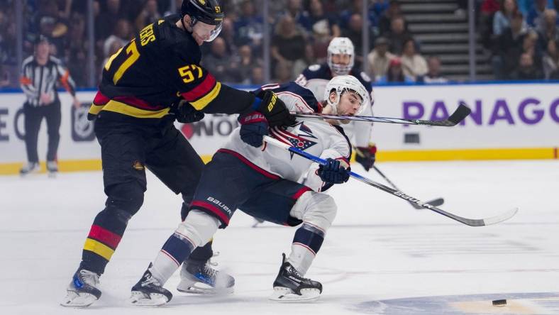 Jan 27, 2024; Vancouver, British Columbia, CAN; Vancouver Canucks defenseman Tyler Myers (57) checks Columbus Blue Jackets forward Adam Fantilli (11) in the third period at Rogers Arena. Canucks won 5-4 in overtime. Mandatory Credit: Bob Frid-USA TODAY Sports