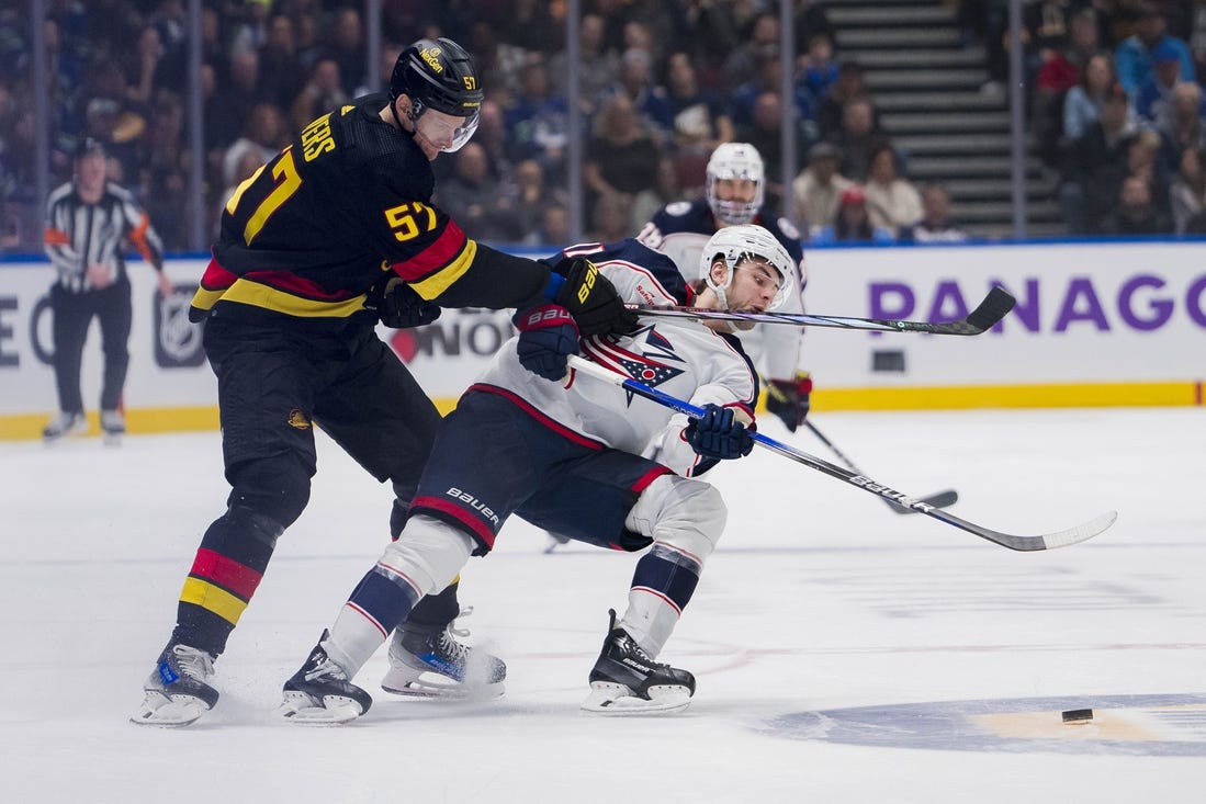 Jan 27, 2024; Vancouver, British Columbia, CAN; Vancouver Canucks defenseman Tyler Myers (57) checks Columbus Blue Jackets forward Adam Fantilli (11) in the third period at Rogers Arena. Canucks won 5-4 in overtime. Mandatory Credit: Bob Frid-USA TODAY Sports