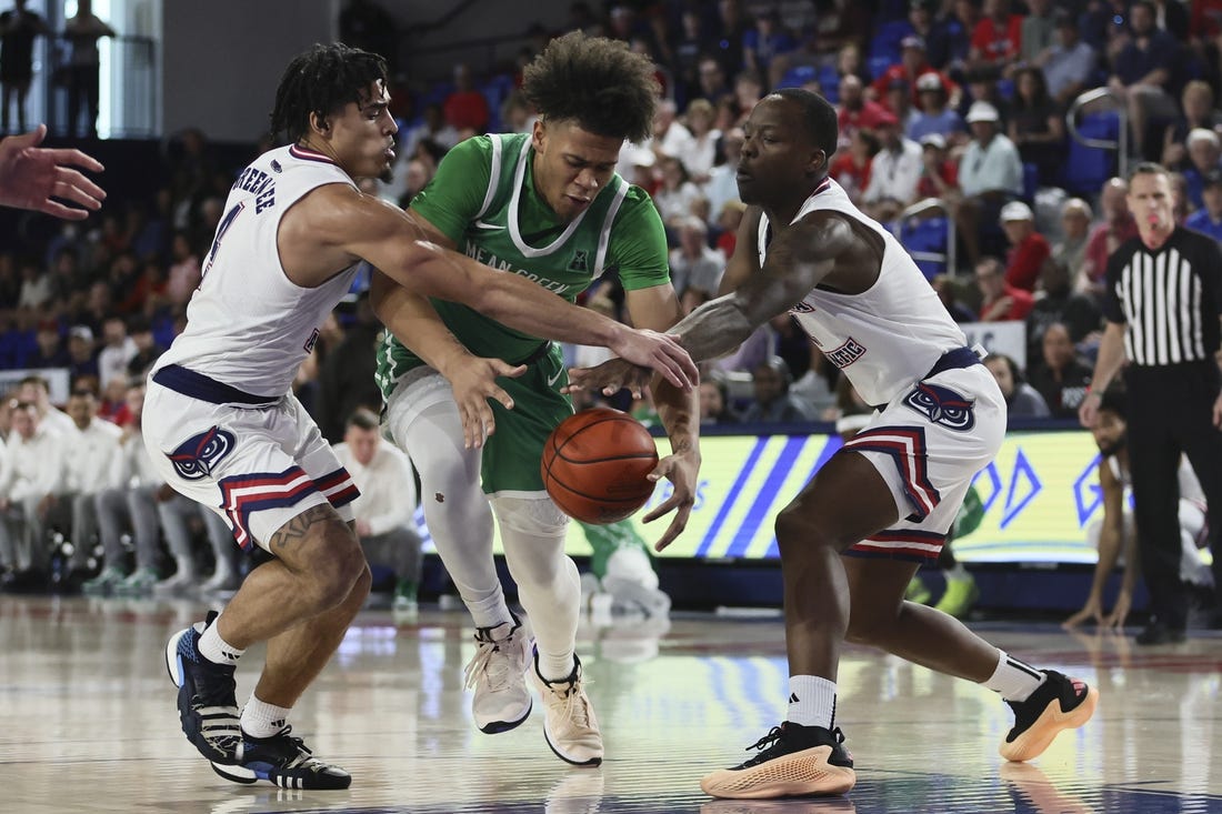 Jan 28, 2024; Boca Raton, Florida, USA; North Texas Mean Green guard CJ Noland (22) drives to the basket against Florida Atlantic Owls guard Bryan Greenlee (4) and guard Johnell Davis (1) during the first half at Eleanor R. Baldwin Arena. Mandatory Credit: Sam Navarro-USA TODAY Sports