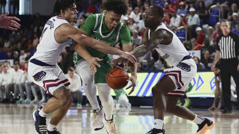 Jan 28, 2024; Boca Raton, Florida, USA; North Texas Mean Green guard CJ Noland (22) drives to the basket against Florida Atlantic Owls guard Bryan Greenlee (4) and guard Johnell Davis (1) during the first half at Eleanor R. Baldwin Arena. Mandatory Credit: Sam Navarro-USA TODAY Sports