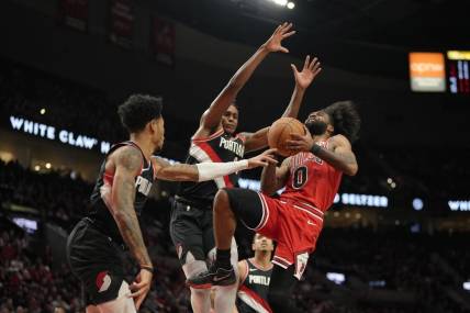 Jan 28, 2024; Portland, Oregon, USA; Chicago Bulls point guard Coby White (0) drives to the basket as he is fouled by Portland Trail Blazers shooting guard Anfernee Simons (1, left) during the first half at Moda Center. Mandatory Credit: Soobum Im-USA TODAY Sports