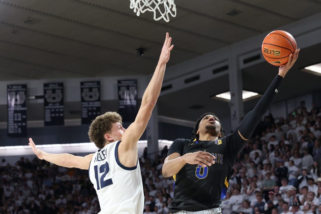 Jan 30, 2024; Logan, Utah, USA; San Jose State Spartans guard Myron Amey Jr. (0) lays the ball up against Utah State Aggies guard Mason Falslev (12) during the first half at Dee Glen Smith Spectrum. Mandatory Credit: Rob Gray-USA TODAY Sports