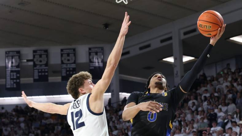 Jan 30, 2024; Logan, Utah, USA; San Jose State Spartans guard Myron Amey Jr. (0) lays the ball up against Utah State Aggies guard Mason Falslev (12) during the first half at Dee Glen Smith Spectrum. Mandatory Credit: Rob Gray-USA TODAY Sports