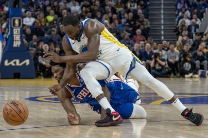 Jan 30, 2024; San Francisco, California, USA;  Philadelphia 76ers center Joel Embiid (21) is called for an offensive foul against Golden State Warriors forward Draymond Green (23) during the second quarter at Chase Center. Mandatory Credit: Neville E. Guard-USA TODAY Sports