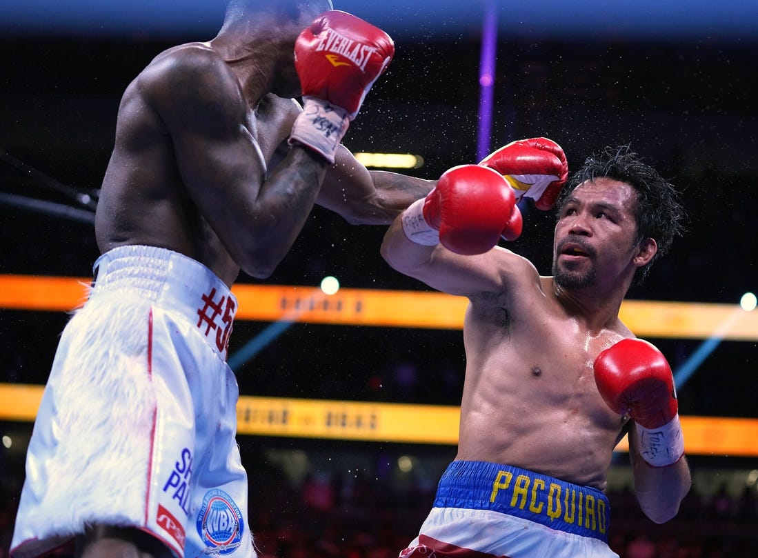 Aug 21, 2021; Las Vegas, Nevada; Manny Pacquiao (right) fights Yordenis Ugas in a world welterweight championship bout at T-Mobile Arena. Mandatory Credit: Stephen R. Sylvanie-USA TODAY Sports