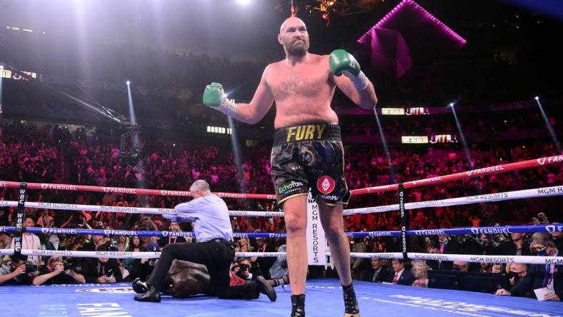 Oct 9, 2021; Las Vegas, Nevada, USA; Deontay Wilder (red/black trunks) is knocked out by Tyson Fury (black/gold trunks) during their WBC/Lineal heavyweight championship boxing match at T-Mobile Arena. Mandatory Credit: Joe Camporeale-USA TODAY Sports