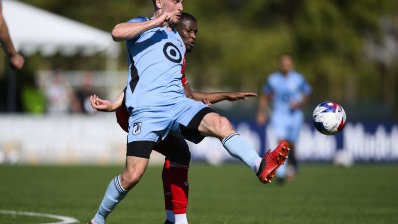 Feb 11, 2023; Indio, CA, USA; Minnesota United Brent Kallman (14) kicks the ball away from New York Red Bulls Elias Manoel (11) at Empire Polo Club. Mandatory Credit: Kelvin Kuo-USA TODAY Sports