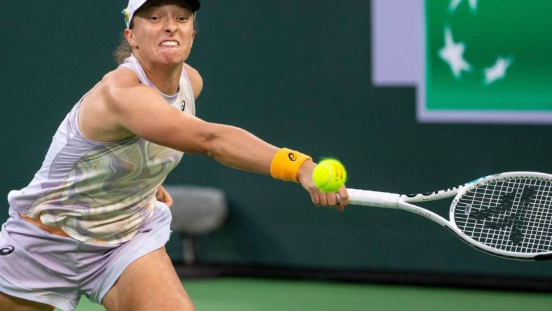 Iga Swiatek of Poland reaches out to hit to Elena Rybakina of Kazakhstan during their semifinal match at the BNP Paribas Open at the Indian Wells Tennis Garden in Indian Wells, Calif., Friday, March 17, 2023.