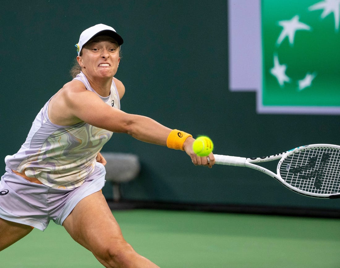 Iga Swiatek of Poland reaches out to hit to Elena Rybakina of Kazakhstan during their semifinal match at the BNP Paribas Open at the Indian Wells Tennis Garden in Indian Wells, Calif., Friday, March 17, 2023.