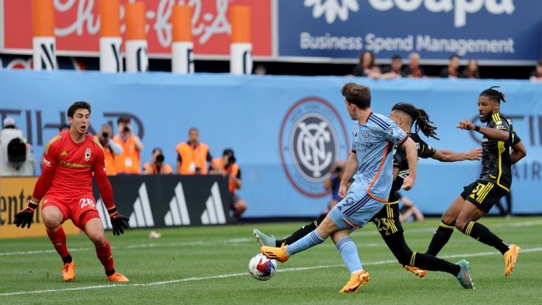 Jun 17, 2023; New York, New York, USA; New York City FC forward Gabriel Segal (19) scores a goal against Columbus Crew SC goalkeeper Patrick Schulte (28) and defenders Mohamed Farsi (23) and Steven Moreira (31) during the second half at Yankee Stadium. Mandatory Credit: Brad Penner-USA TODAY Sports