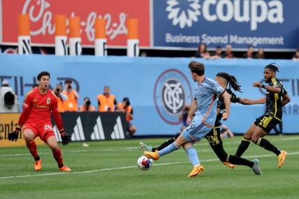 Jun 17, 2023; New York, New York, USA; New York City FC forward Gabriel Segal (19) scores a goal against Columbus Crew SC goalkeeper Patrick Schulte (28) and defenders Mohamed Farsi (23) and Steven Moreira (31) during the second half at Yankee Stadium. Mandatory Credit: Brad Penner-USA TODAY Sports