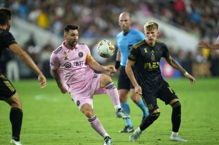 Sep 3, 2023; Los Angeles, California, USA; Inter Miami CF forward Lionel Messi (10) and LAFC midfielder Mateusz Bogusz (19) battle for the ball at BMO Stadium. Mandatory Credit: Kirby Lee-USA TODAY Sports