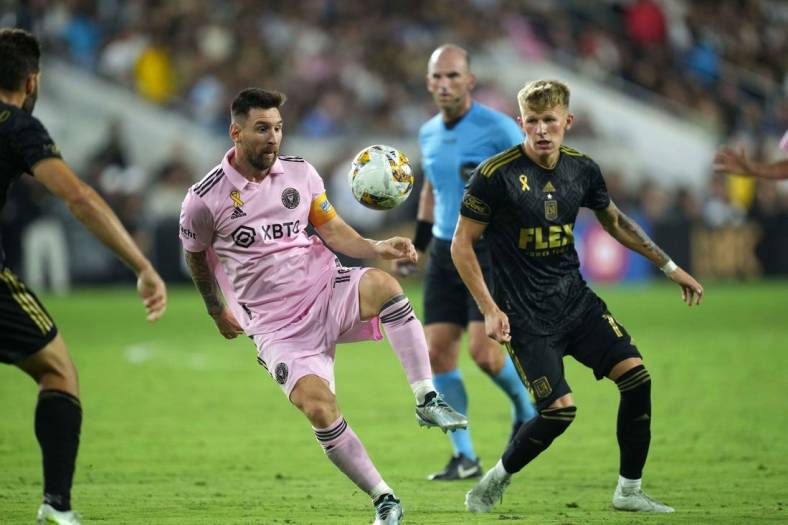 Sep 3, 2023; Los Angeles, California, USA; Inter Miami CF forward Lionel Messi (10) and LAFC midfielder Mateusz Bogusz (19) battle for the ball at BMO Stadium. Mandatory Credit: Kirby Lee-USA TODAY Sports