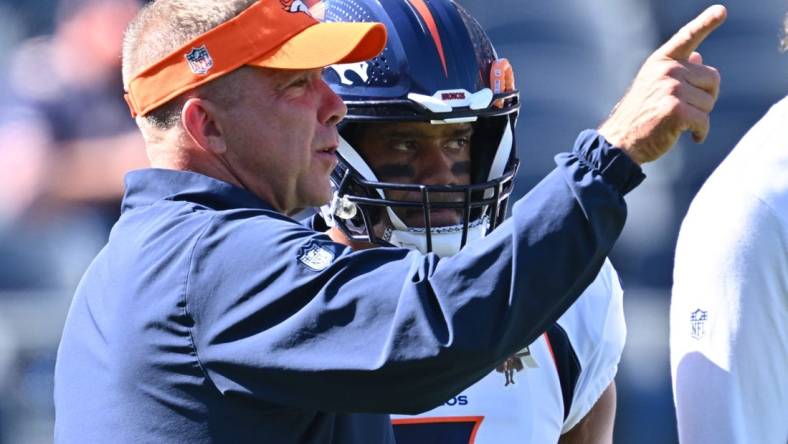 Oct 1, 2023; Chicago, Illinois, USA;  Denver Broncos head coach Sean Payton talks with quarterback Russell Wilson (3) before a game against the Chicago Bears at Soldier Field. Mandatory Credit: Jamie Sabau-USA TODAY Sports