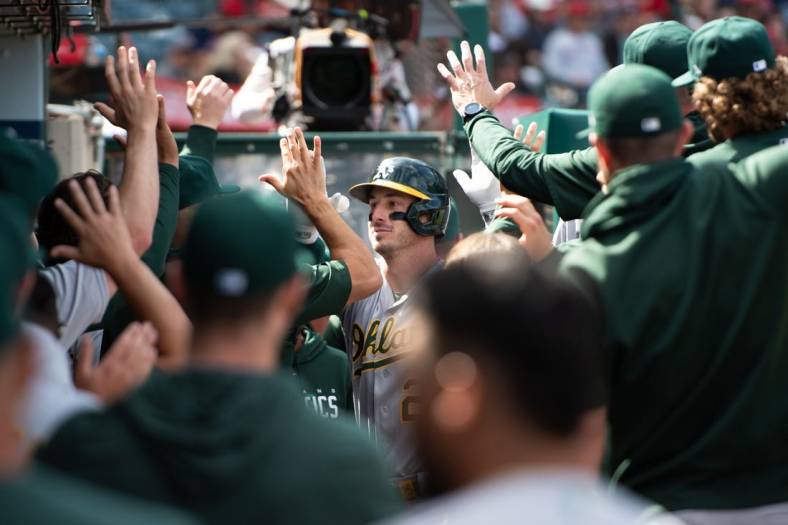 Oct 1, 2023; Anaheim, California, USA; Oakland Athletics designated hitter Brent Rooker (25) celebrates with teammates in the dugout after hitting a home run against the Los Angeles Angels during the eighth inning at Angel Stadium. Mandatory Credit: Jonathan Hui-USA TODAY Sports