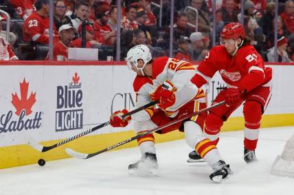 Oct 22, 2023; Detroit, Michigan, USA;  Calgary Flames center Elias Lindholm (28) and Detroit Red Wings defenseman Moritz Seider (53) battle for the puck in the third period at Little Caesars Arena. Mandatory Credit: Rick Osentoski-USA TODAY Sports