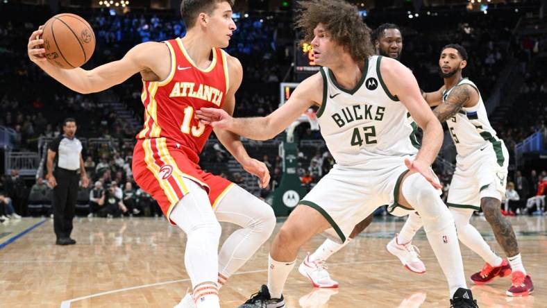 Oct 29, 2023; Milwaukee, Wisconsin, USA; Atlanta Hawks guard Bogdan Bogdanovic (13) attempts to drive against Milwaukee Bucks center Robin Lopez (42) in the second half at Fiserv Forum. Mandatory Credit: Michael McLoone-USA TODAY Sports