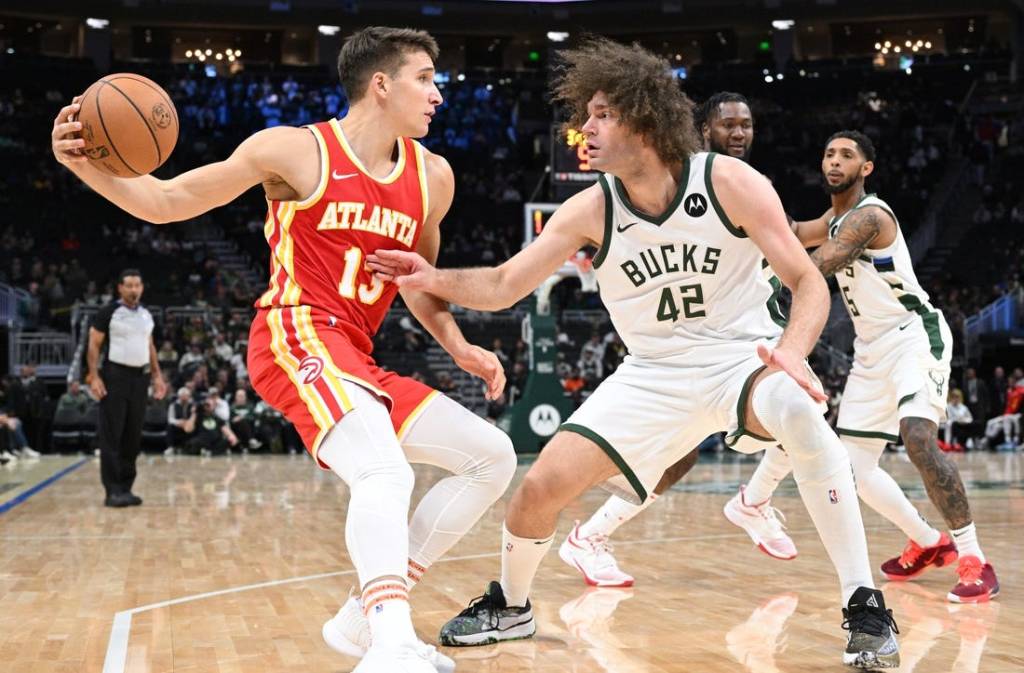 Oct 29, 2023; Milwaukee, Wisconsin, USA; Atlanta Hawks guard Bogdan Bogdanovic (13) attempts to drive against Milwaukee Bucks center Robin Lopez (42) in the second half at Fiserv Forum. Mandatory Credit: Michael McLoone-USA TODAY Sports