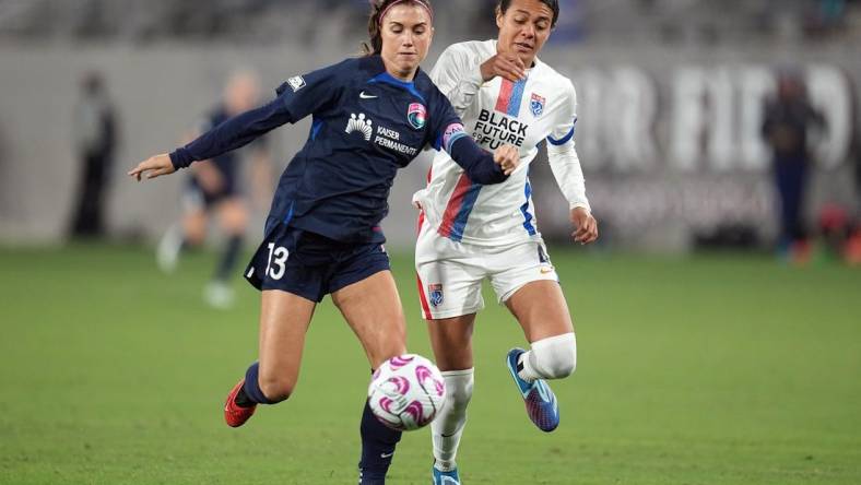 Nov 5, 2023; San Diego, California, USA;  San Diego Wave FC forward Alex Morgan (13) and OL Reign defender Alana Cook (4) battle for the ball in the second half at Snapdragon Stadium. Mandatory Credit: Ray Acevedo-USA TODAY Sports