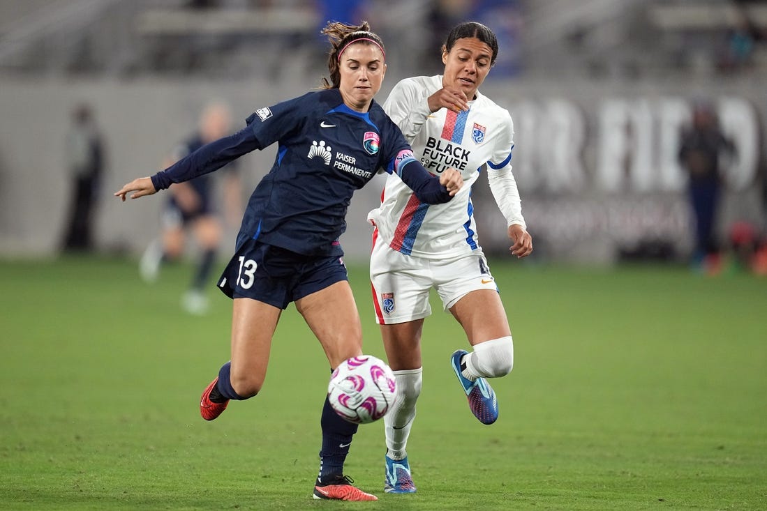 Nov 5, 2023; San Diego, California, USA;  San Diego Wave FC forward Alex Morgan (13) and OL Reign defender Alana Cook (4) battle for the ball in the second half at Snapdragon Stadium. Mandatory Credit: Ray Acevedo-USA TODAY Sports