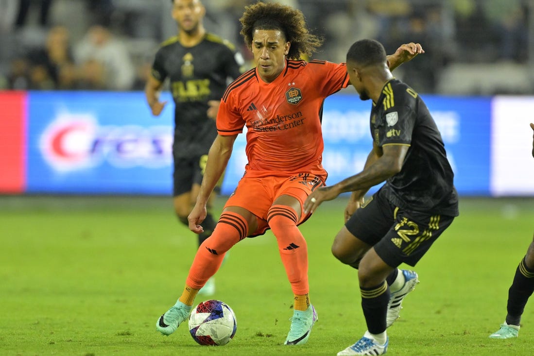 Dec 2, 2023; Los Angeles, California, USA; Houston Dynamo midfielder Adalberto Carrasquilla (20) kicks the ball past Los Angeles FC defender Diego Palacios (12) in the second half for the MLS Cup Western Conference Final at BMO Stadium. Mandatory Credit: Jayne Kamin-Oncea-USA TODAY Sports