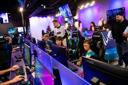 Jonathan Walker (standing, center) helps a group of young gamers during a pre-grand opening event at Valhallan Esports Training on Thursday, Nov. 30, 2023, in Camp Hill. Walker is the Apex Legends coach at Valhallan.
