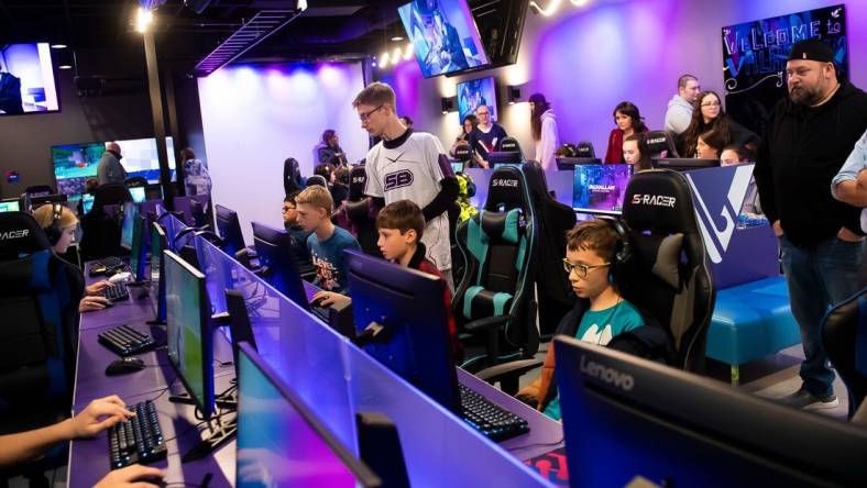 Jonathan Walker (standing, center) helps a group of young gamers during a pre-grand opening event at Valhallan Esports Training on Thursday, Nov. 30, 2023, in Camp Hill. Walker is the Apex Legends coach at Valhallan.