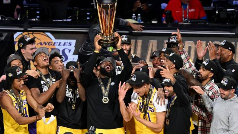 Dec 9, 2023; Las Vegas, Nevada, USA; Los Angeles Lakers forward LeBron James (23) hoists the NBA Cup and celebrates with teammates after winning the NBA In-Season Tournament Championship game against the Indiana Pacers at T-Mobile Arena. Mandatory Credit: Candice Ward-USA TODAY Sports