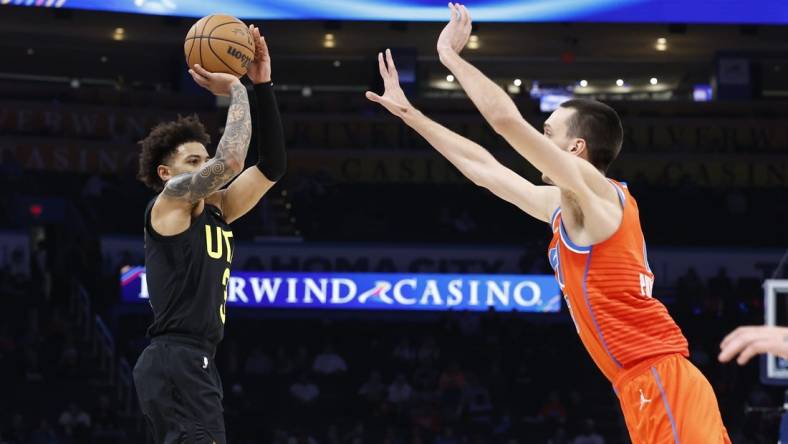 Dec 11, 2023; Oklahoma City, Oklahoma, USA; Utah Jazz guard Keyonte George (3) shoot a three-point basket as Oklahoma City Thunder forward Aleksej Pokusevski (17) defends during the second half at Paycom Center. Mandatory Credit: Alonzo Adams-USA TODAY Sports