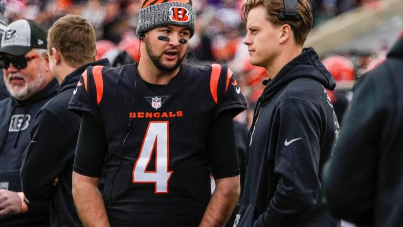 Cincinnati Bengals quarterbacks AJ McCarron (4) and Joe Burrow (9) talk as the Bengals take on Minnesota Vikings at Paycor Stadium Saturday, December 16, 2023.