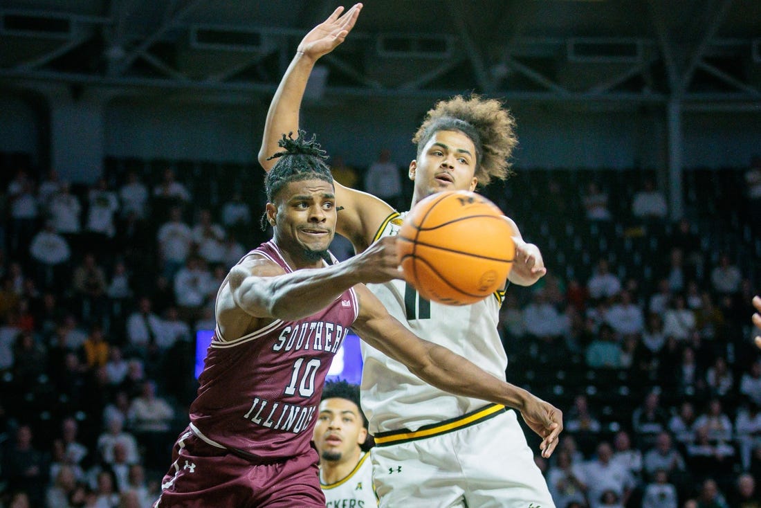 Dec 16, 2023; Wichita, Kansas, USA; Southern Illinois Salukis Xavier Johnson (10) passes around Wichita State Shockers forward Kenny Pohto (11) during the second half at Charles Koch Arena. Mandatory Credit: William Purnell-USA TODAY Sports