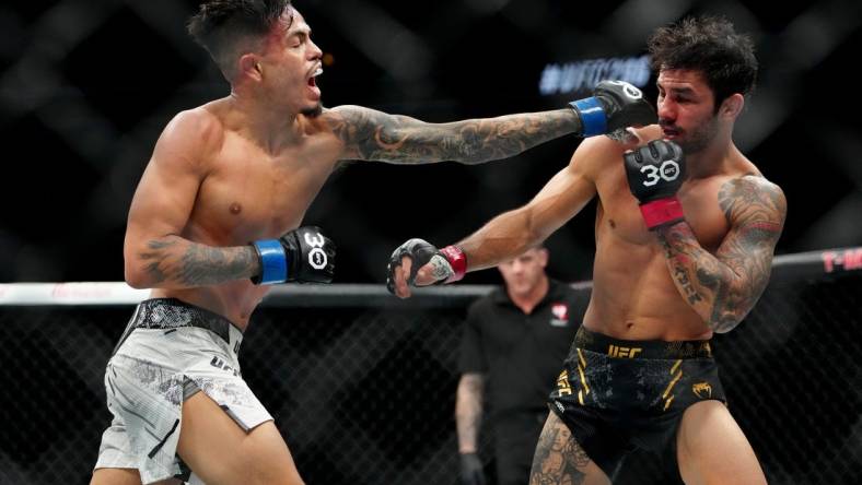 Dec 16, 2023; Las Vegas, Nevada, USA; Alexandre Pantoja (red gloves) fights Brandon Royval (blue gloves) during UFC 296 at T-Mobile Arena. Mandatory Credit: Stephen R. Sylvanie-USA TODAY Sports