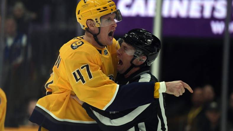 Dec 19, 2023; Nashville, Tennessee, USA; Nashville Predators right wing Michael McCarron (47) is held back by linesman Libor Suchanek (60) before receiving a game misconduct during the first period against the Vancouver Canucks at Bridgestone Arena. Mandatory Credit: Christopher Hanewinckel-USA TODAY Sports