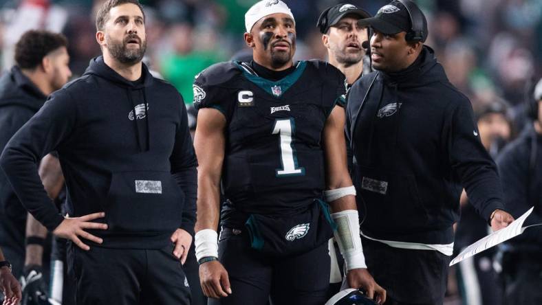 Dec 25, 2023; Philadelphia, Pennsylvania, USA; Philadelphia Eagles head coach Nick Sirianni (L) and quarterback Jalen Hurts (1) and offensive coordinator Brian Johnson (R) talk during the second quarter against the New York Giants at Lincoln Financial Field. Mandatory Credit: Bill Streicher-USA TODAY Sports