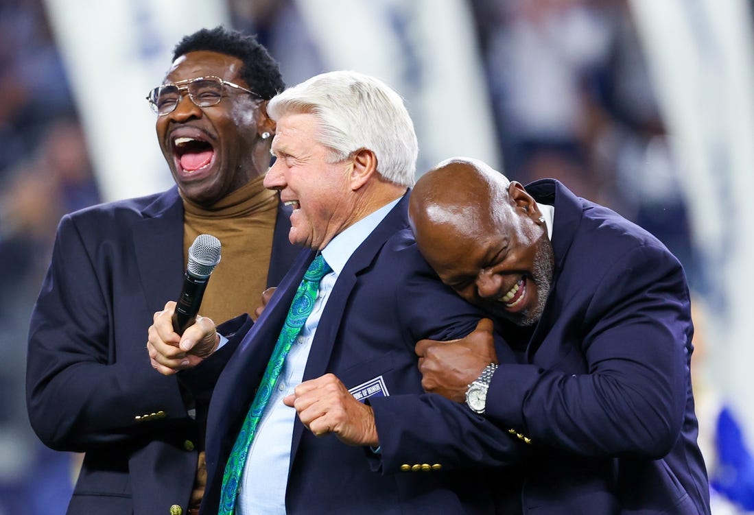 Dec 30, 2023; Arlington, Texas, USA;  Dallas Cowboys former head coach Jimmy Johnson celebrates with former players Michael Irvin and Emmitt Smith after being inducted into the ring of honor at halftime of the game against the Detroit Lions at AT&T Stadium. Mandatory Credit: Kevin Jairaj-USA TODAY Sports