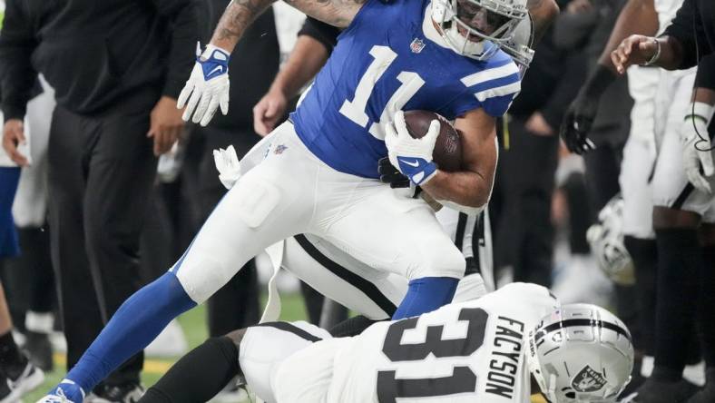 Dec 31, 2023; Indianapolis, Indiana, USA; Indianapolis Colts wide receiver Michael Pittman Jr. (11) runs out of bounds as Las Vegas Raiders cornerback Brandon Facyson (31) rolls at his feet during a game against the Las Vegas Raiders at Lucas Oil Stadium. Mandatory Credit: Bob Scheer-USA TODAY Sports